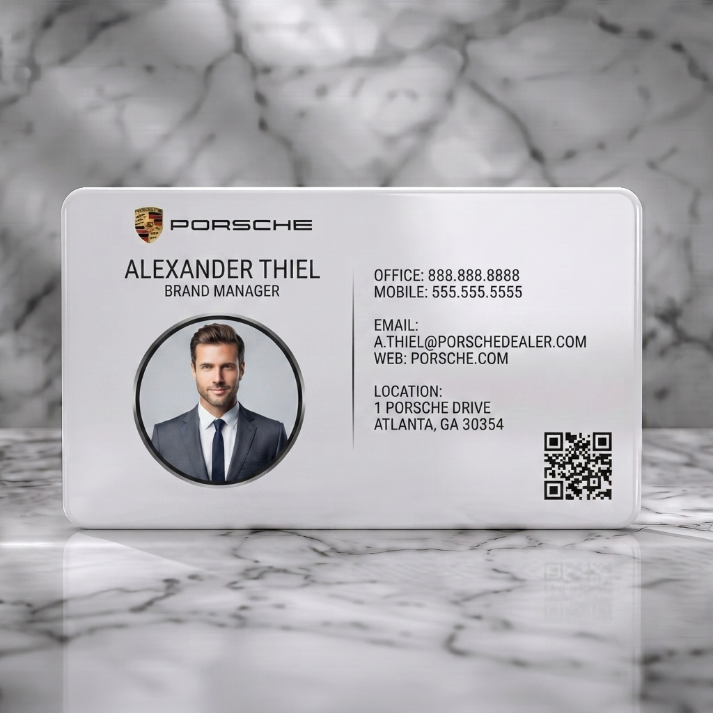 Solid white PVC business card featuring a sleek black and silver design, sans-serif typography, Porsche logo, professional headshot, and QR code