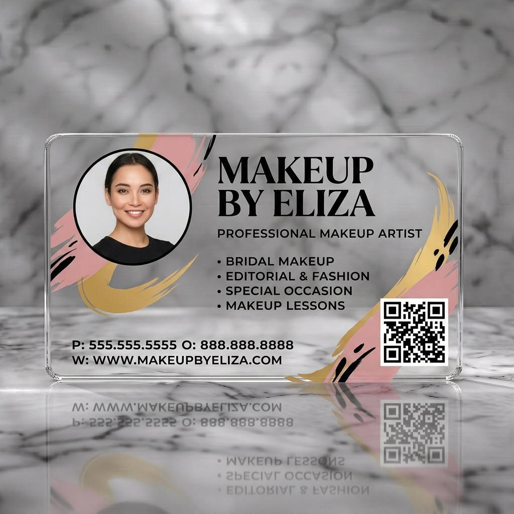 Clear plastic business card featuring a stylish photo, elegant black serif typography, artistic gold and blush brushstrokes, and a QR code
