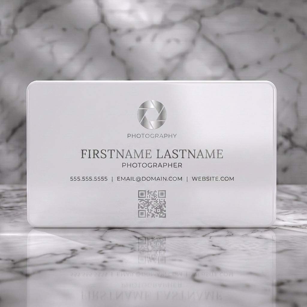 Solid white PVC business card featuring clean, modern style with a silver aperture icon, white typography, and QR code