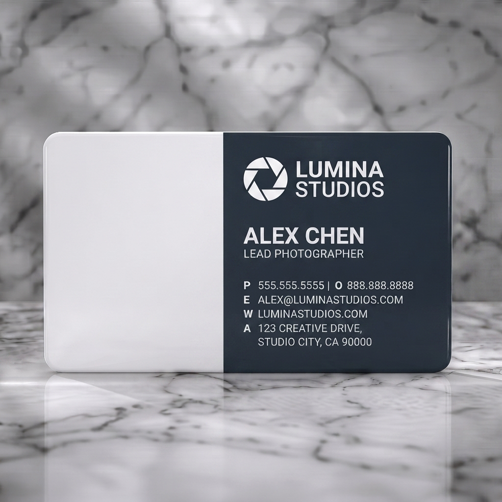 Solid white PVC business card featuring a modern dark gray design with white text, a camera aperture logo, and abstract photography lines