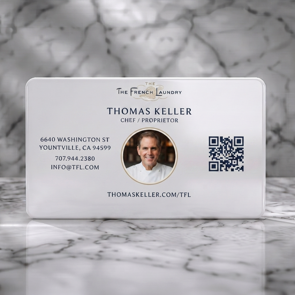 Solid white PVC business card featuring elegant cream and blue design with classic serif typography, chef headshot, and QR code