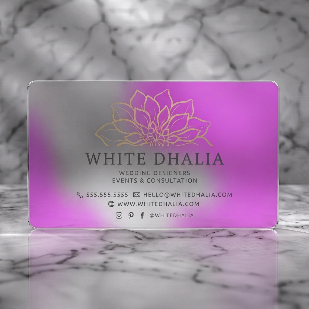 Frosted translucent plastic business card featuring gold dahlia flower logo, elegant dark typography, and minimalist contact icons on a cream card